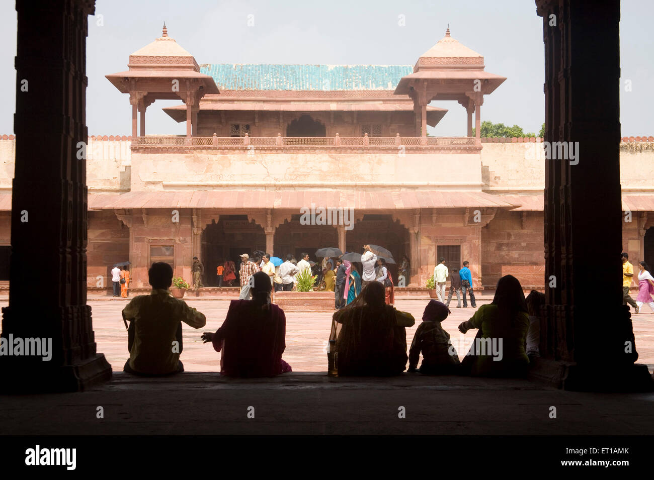 I turisti indiani in appoggio sul lato ; sabbia rossa architettura in pietra di Jodhabai Mahal ; Fatehpur Sikari ; Uttar Pradesh ; India Foto Stock