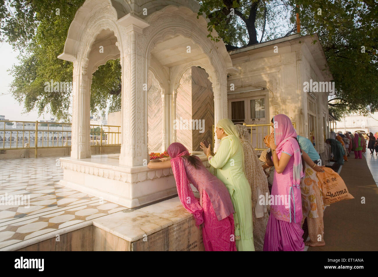La religione sikh devoto inginocchiarsi Hari Mandir Sahib e pregando ; pattern in marmo design floreale ; Swarn Mandir tempio dorato ; Amritsar Foto Stock