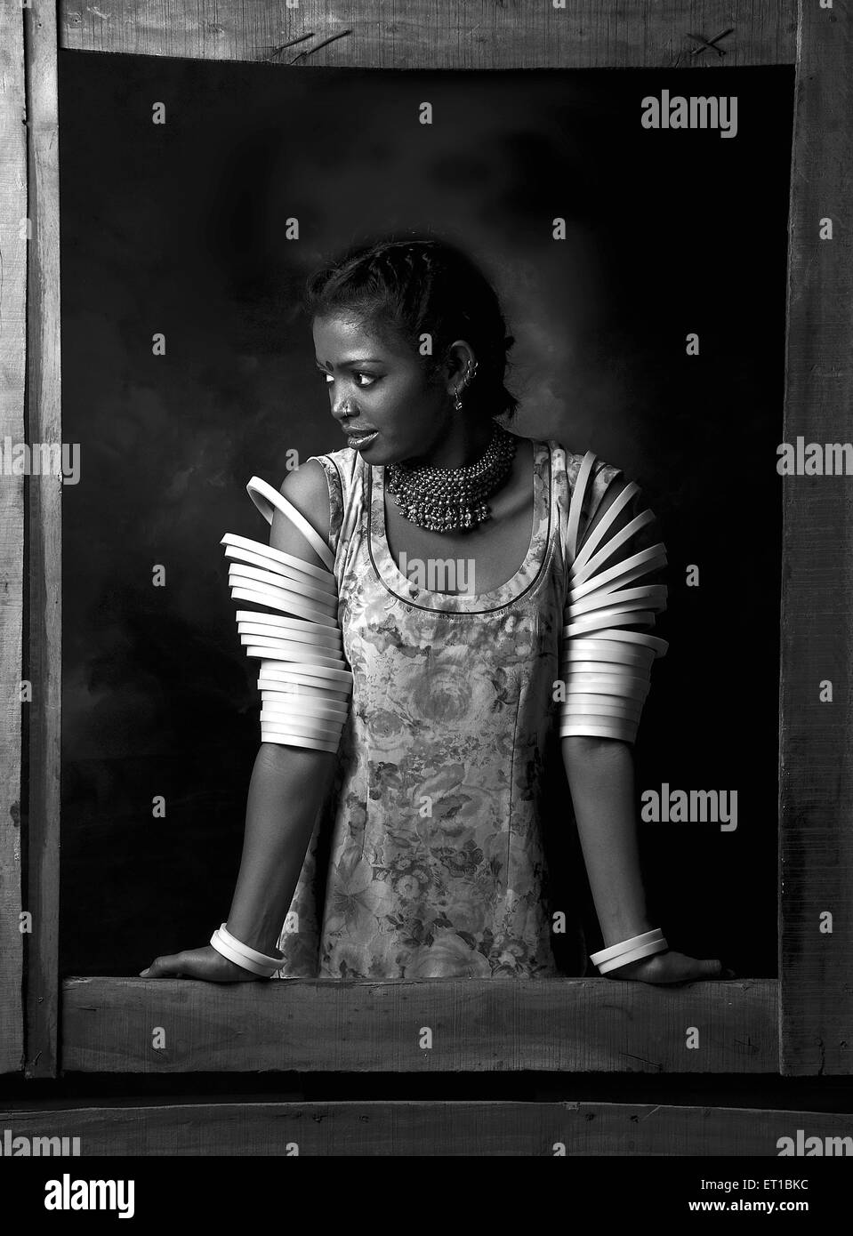 Signora in piedi nella finestra indossando schiave in entrambe le mani ; Jodhpur ; Rajasthan ; India Signor#746B Foto Stock