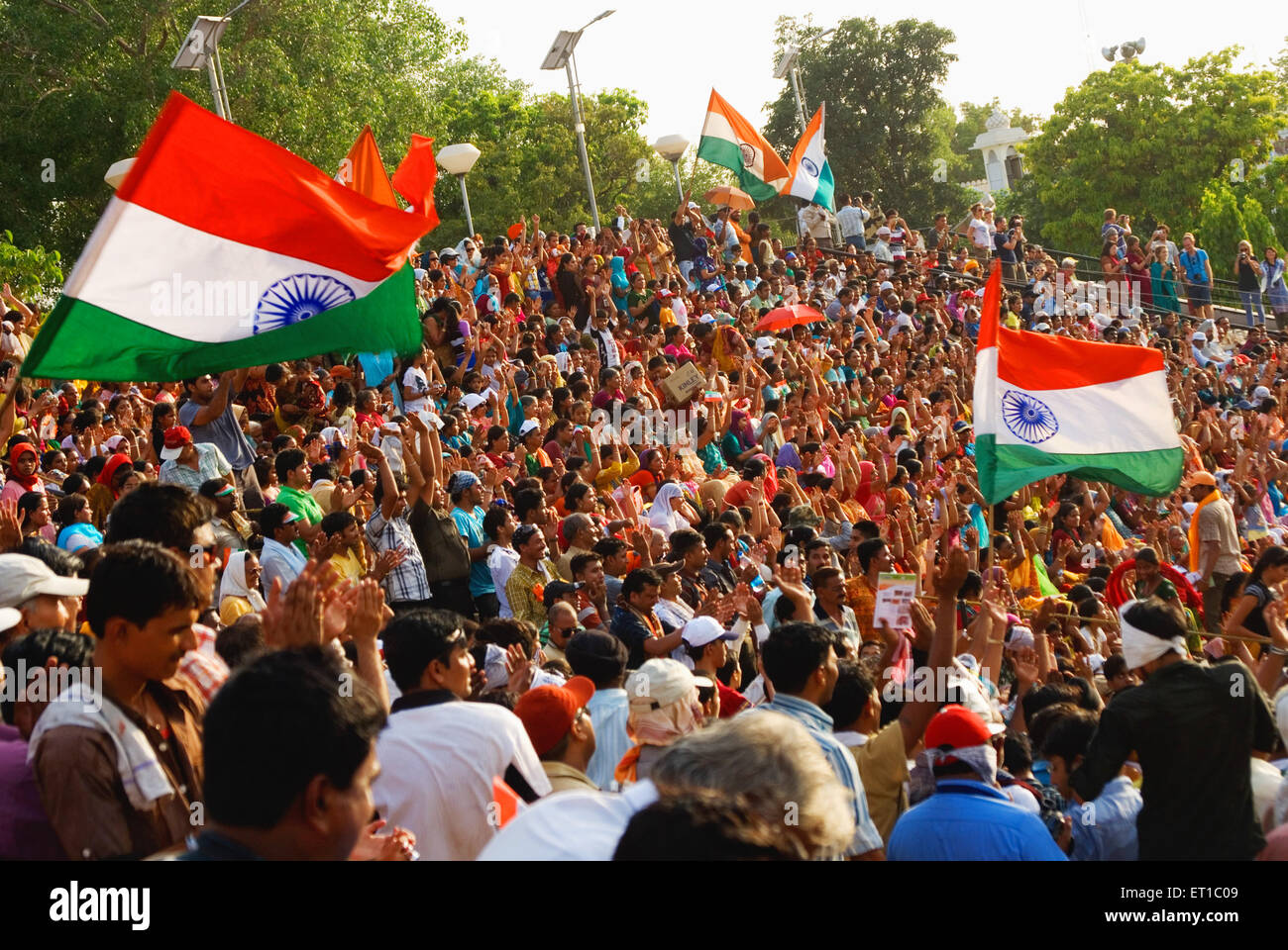 Persone con bandiera nazionale guardando parade wagha border Punjab India Asia Foto Stock