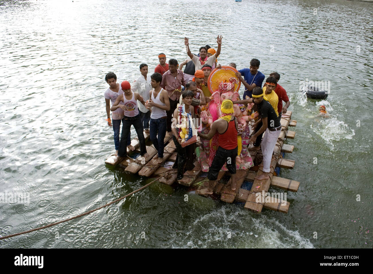 I volontari che trasportano Ganpati su zattera di bambù Visarjan Jodhpur Rajasthan India Asia Foto Stock