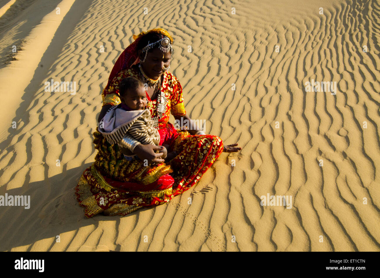 Donna con il Figlio nel suo grembo Seduti sulle dune di sabbia del deserto di Thar Jaisalmer Rajasthan India Signor # 704 Foto Stock
