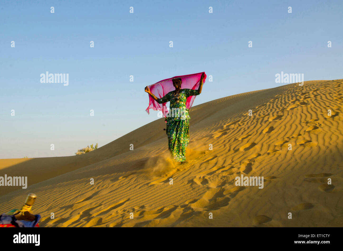 Donna in corsa verso il basso sulle dune di sabbia del deserto di Thar Jaisalmer Rajasthan signor # 704 Foto Stock