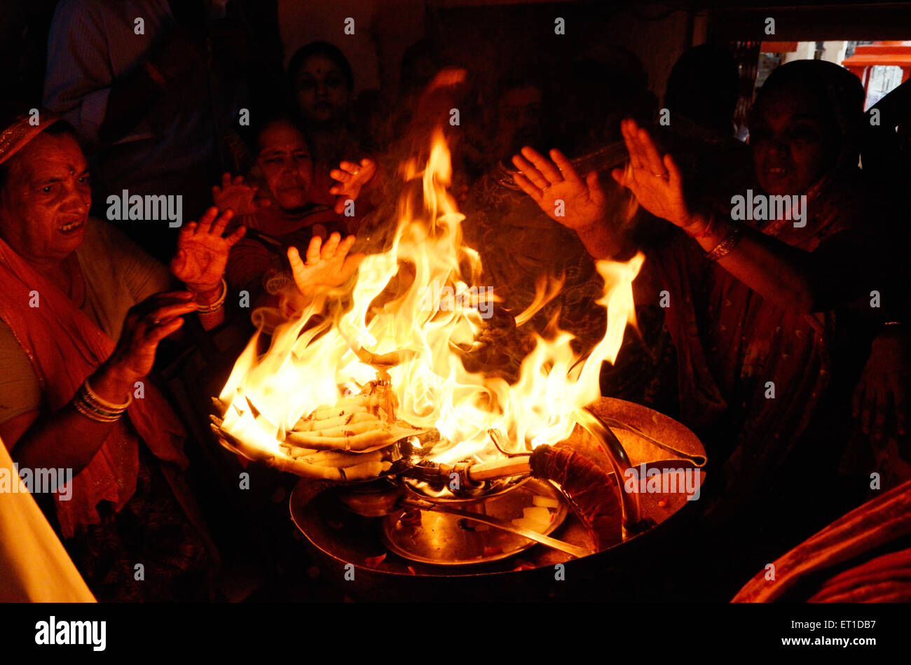 Donne che prendono calore, fuoco sacro, tempio aarti, Jodhpur, Rajasthan, India, Asia Foto Stock