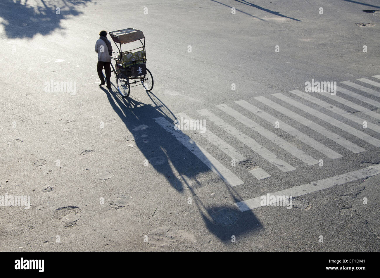In rickshaw driver ciclo di trascinamento di risciò a Jaipur in Rajasthan in India Foto Stock