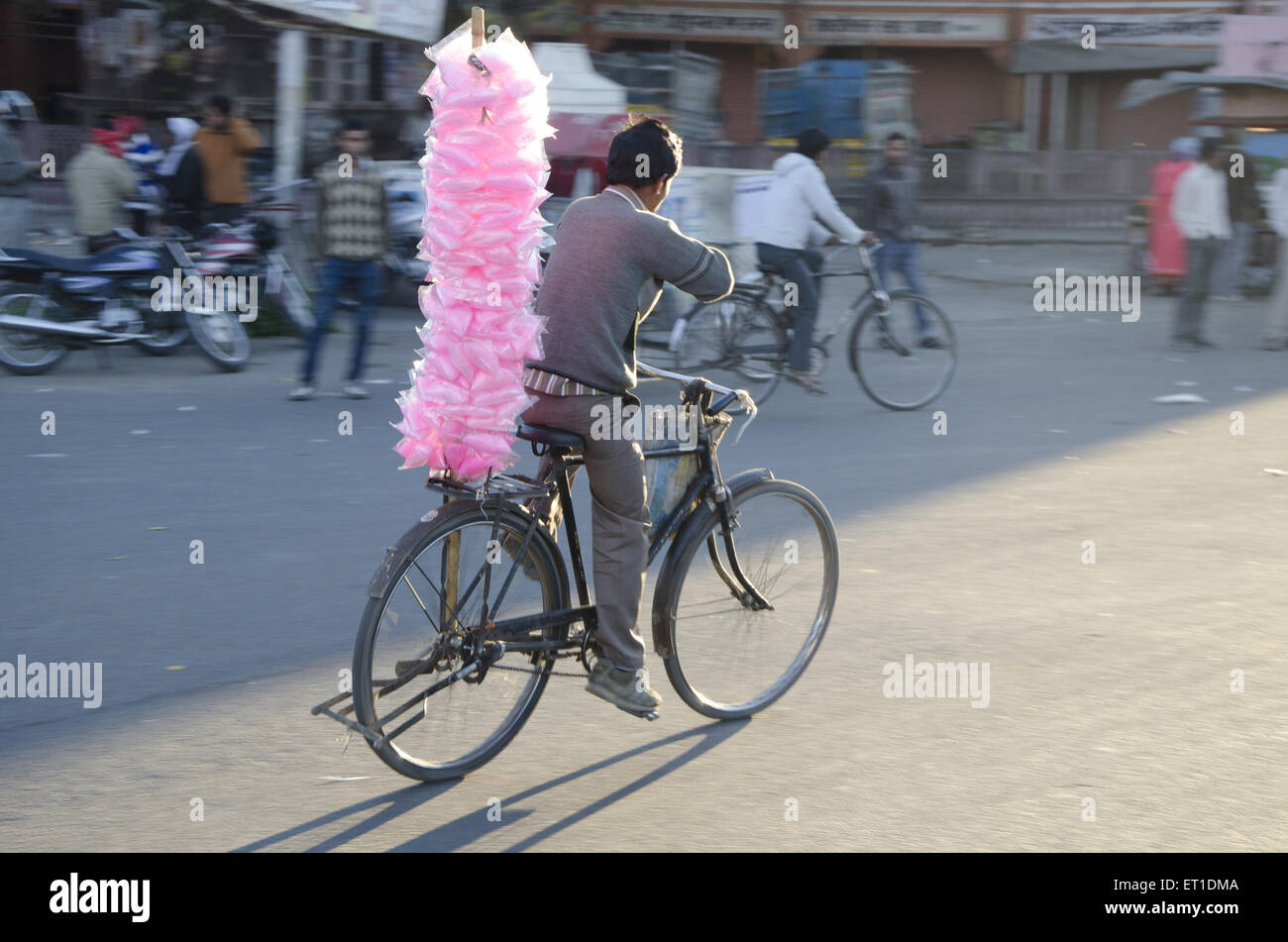 Uomo che porta zucchero candito sul ciclo a Jaipur India Rajasthan Foto Stock