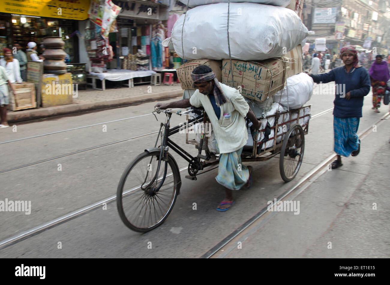 Lavoratore tirando balla su triciclo rickshaw Kolkata West Bengal India Asia Foto Stock