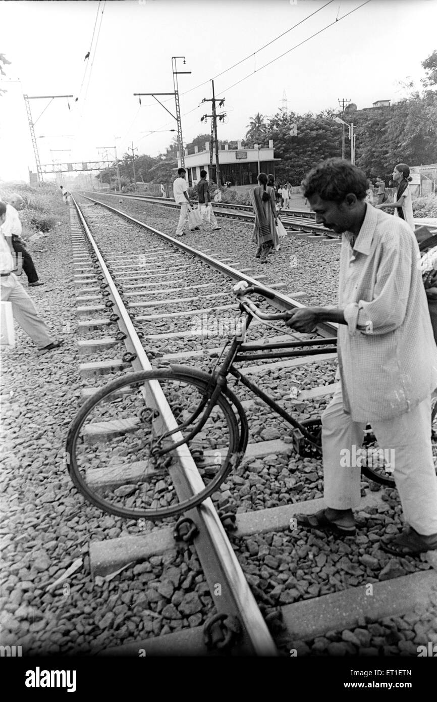 Uomo con attraversamento del ciclo binario ferroviario ; Wadala ; Mumbai Bombay ; Maharashtra ; India Foto Stock