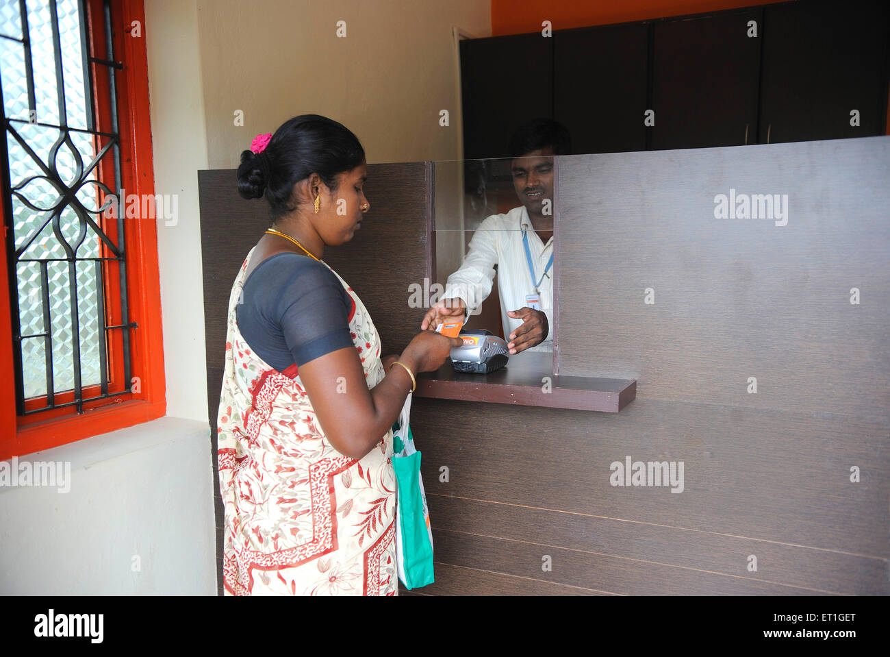 Signora rurale che mostra la carta d'identità in banca dalle ONG gramin kshtriya servizi finanziari IFMR foundation Thanjavur India del Sud Foto Stock