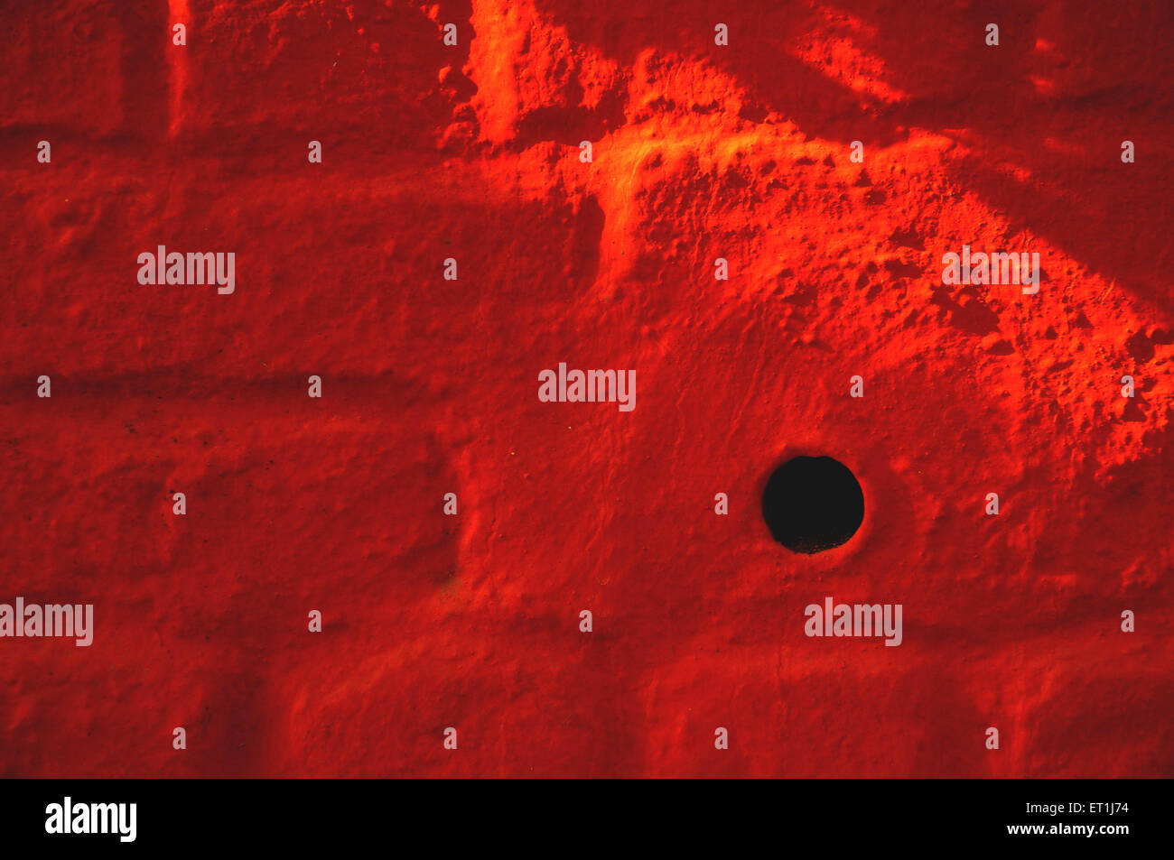 buco su muro di mattoni rossi Foto Stock