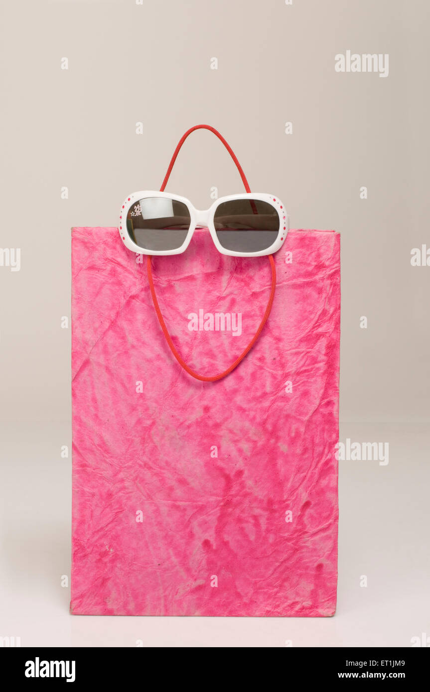 borsa in carta rosa con occhiali da sole Foto Stock