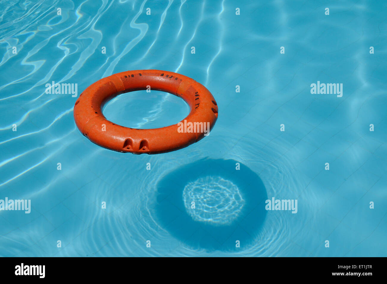 Anello bagnino galleggiante su acqua blu in piscina Foto Stock