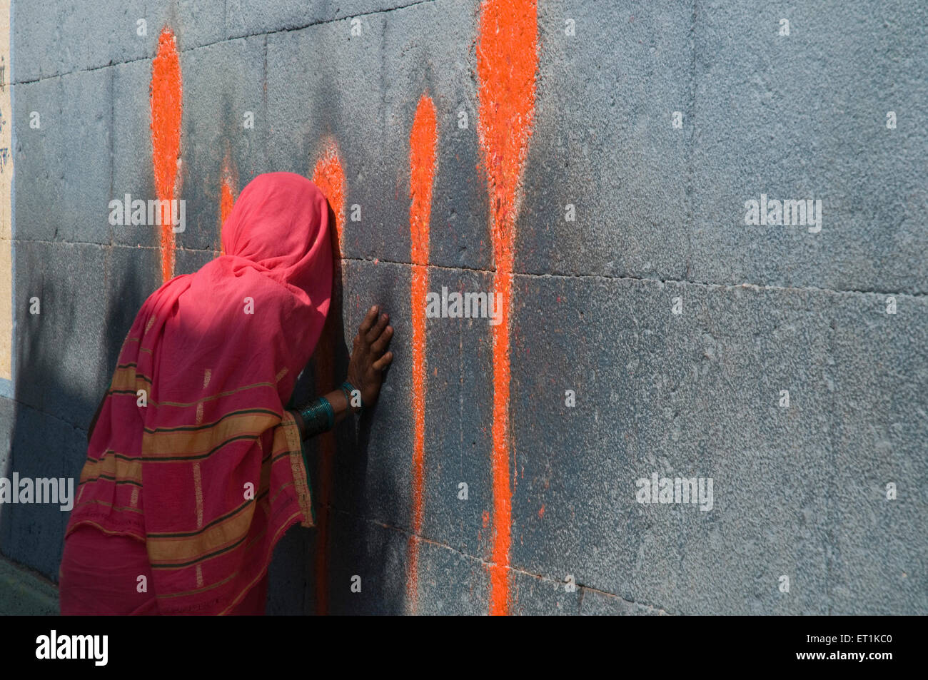 Donna che offre preghiere sul muro tempio di Jagdamba Siddhatek Maharashtra India Asia Foto Stock