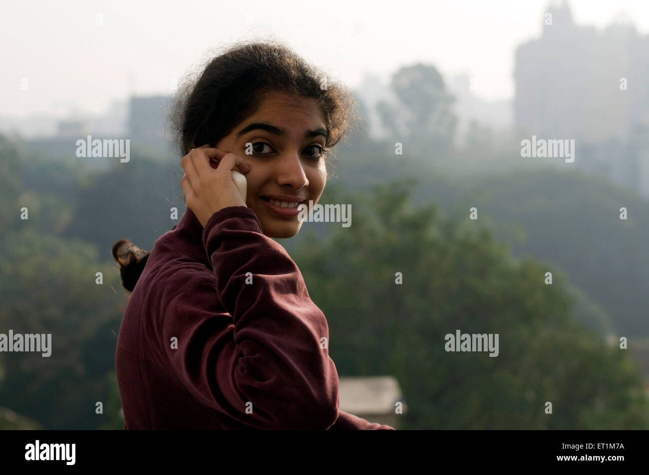 Una ragazza parlando al telefono cellulare in inverno mattina Pune Maharashtra India Asia signor# 191 1 Foto Stock