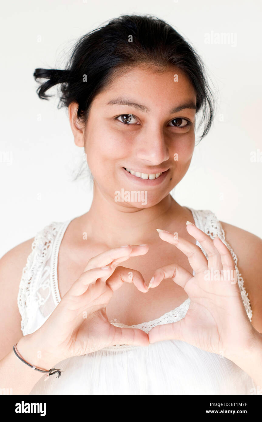 Una ragazza che mostra un cuore fatto con le sue dita del Maharashtra Pune India Asia signor#686EE Foto Stock