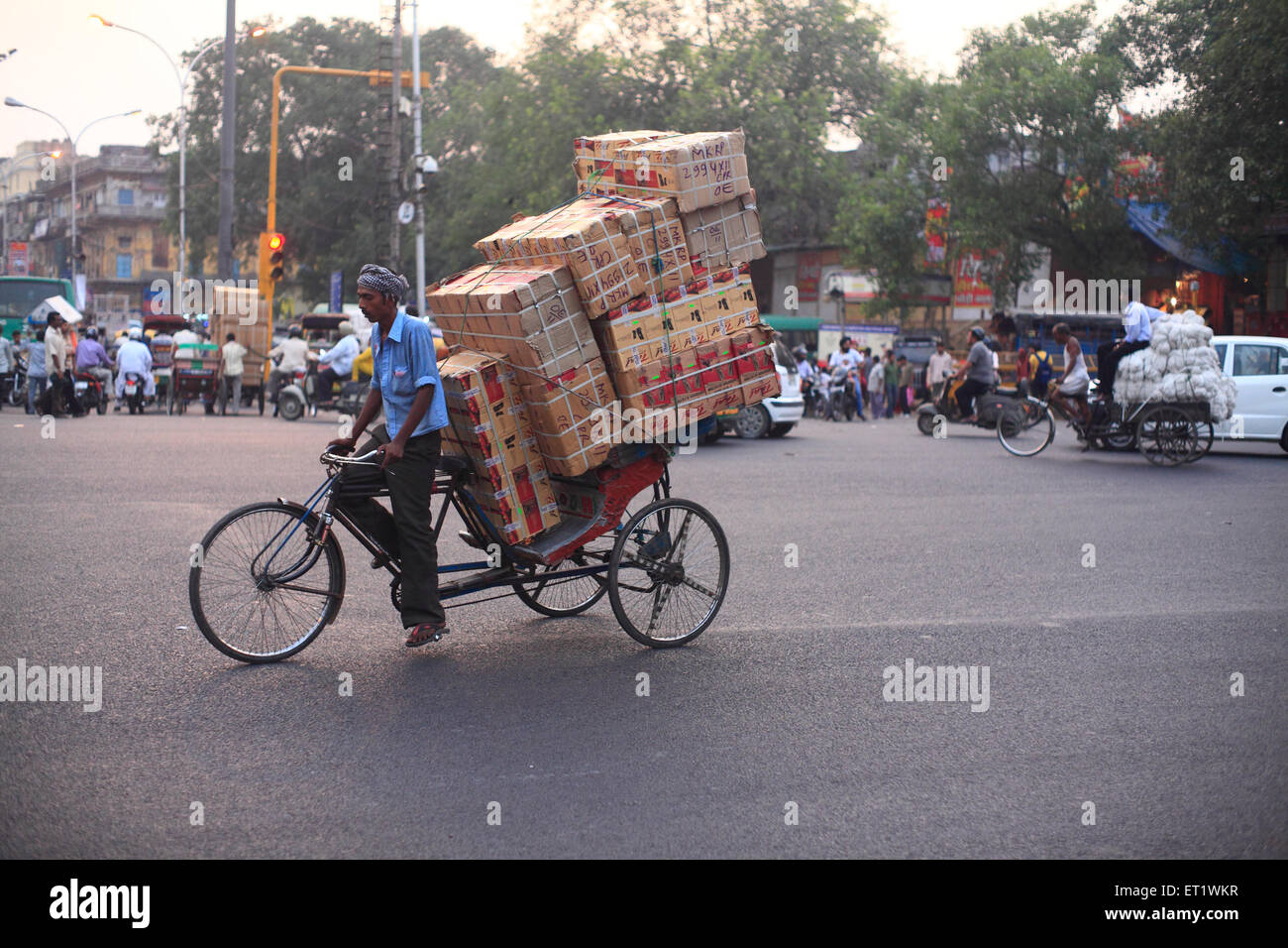 In rickshaw lavoratori mano tirare il carrello carico di merci a Delhi Foto Stock