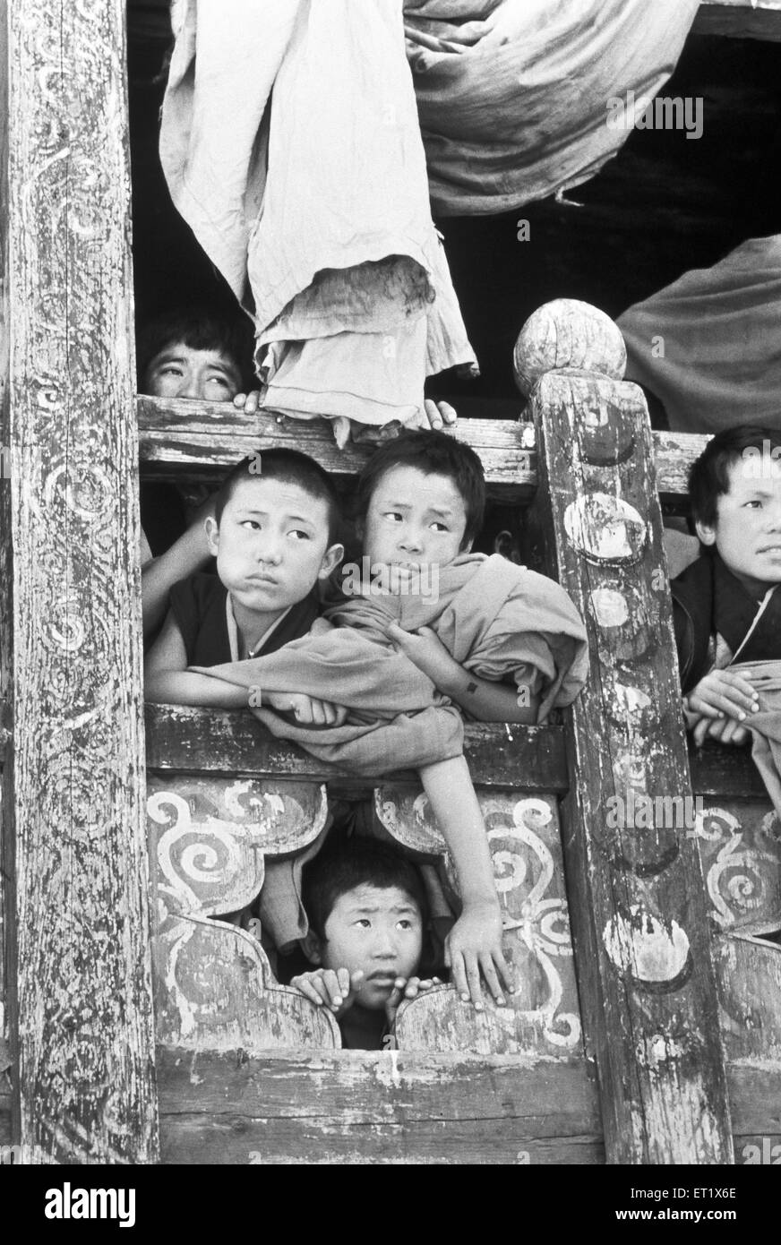 I giovani monaci sbucano dalla finestra nel monastero di Paro ; Bhutan ; Asia ; vecchio quadro del 1900 Foto Stock