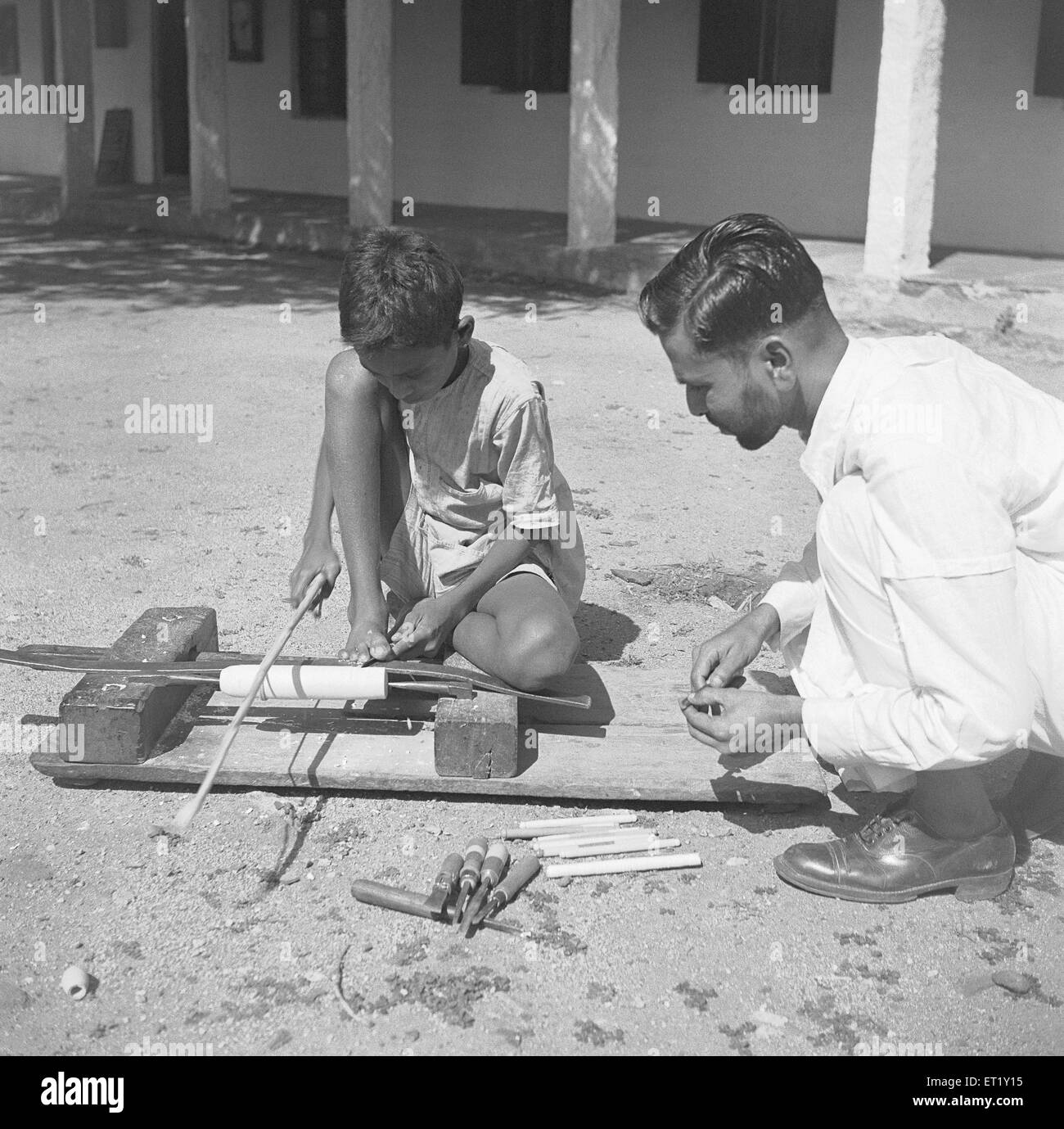 Ragazzo giovane che usa il tornio rotante portatile per legno ; Channapatna ; Karnataka ; India ; Asia ; vecchia annata del 1900 Foto Stock