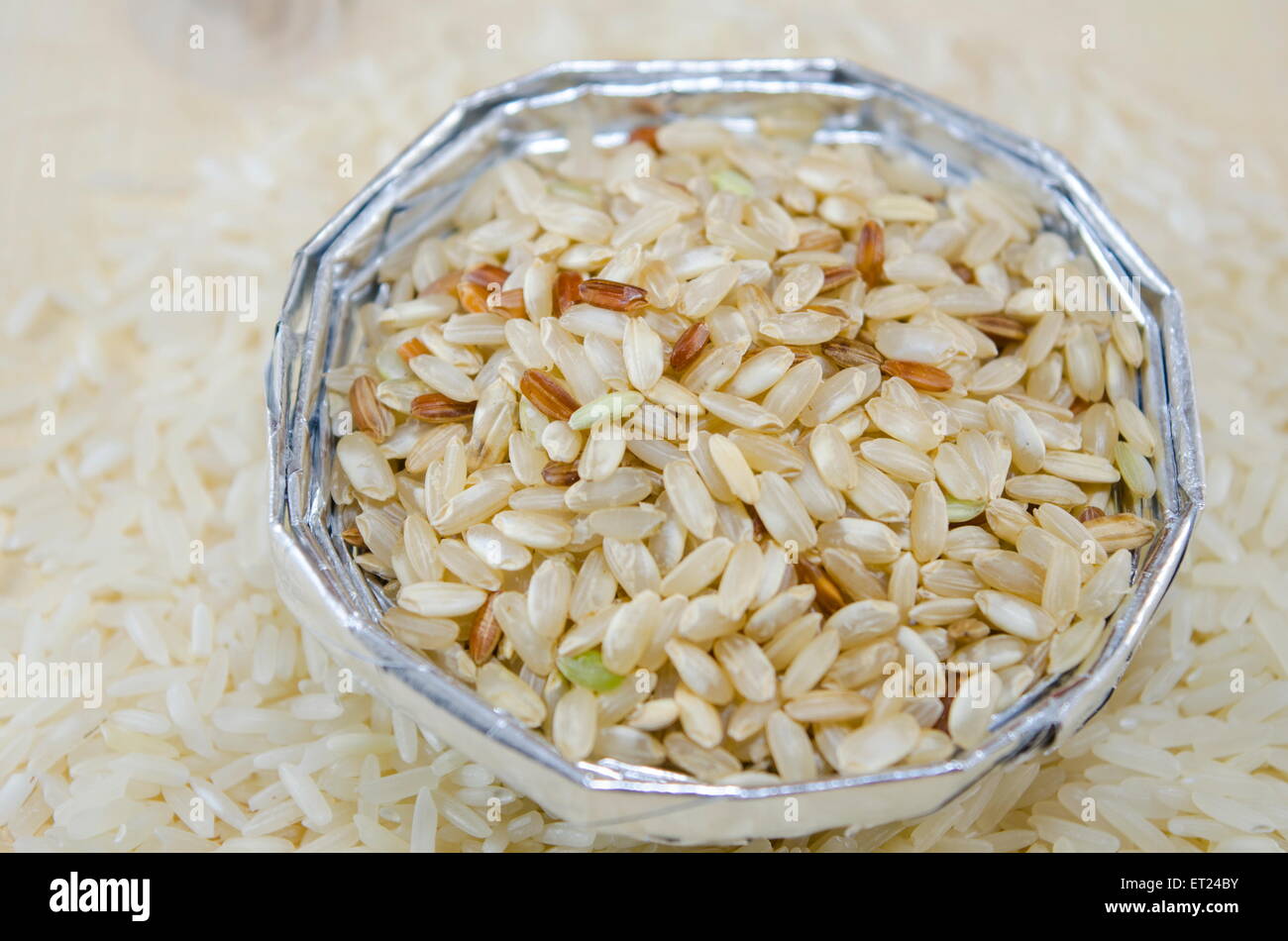 Il riso in un recipiente di alluminio su un tavolo ricoperto con riso Foto Stock