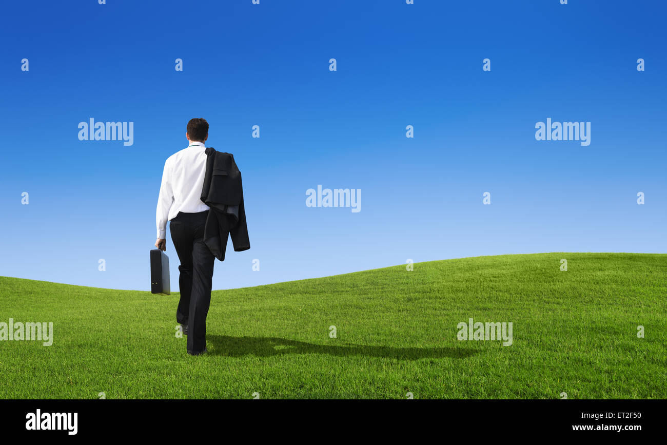 Imprenditore a piedi su per la collina Foto Stock