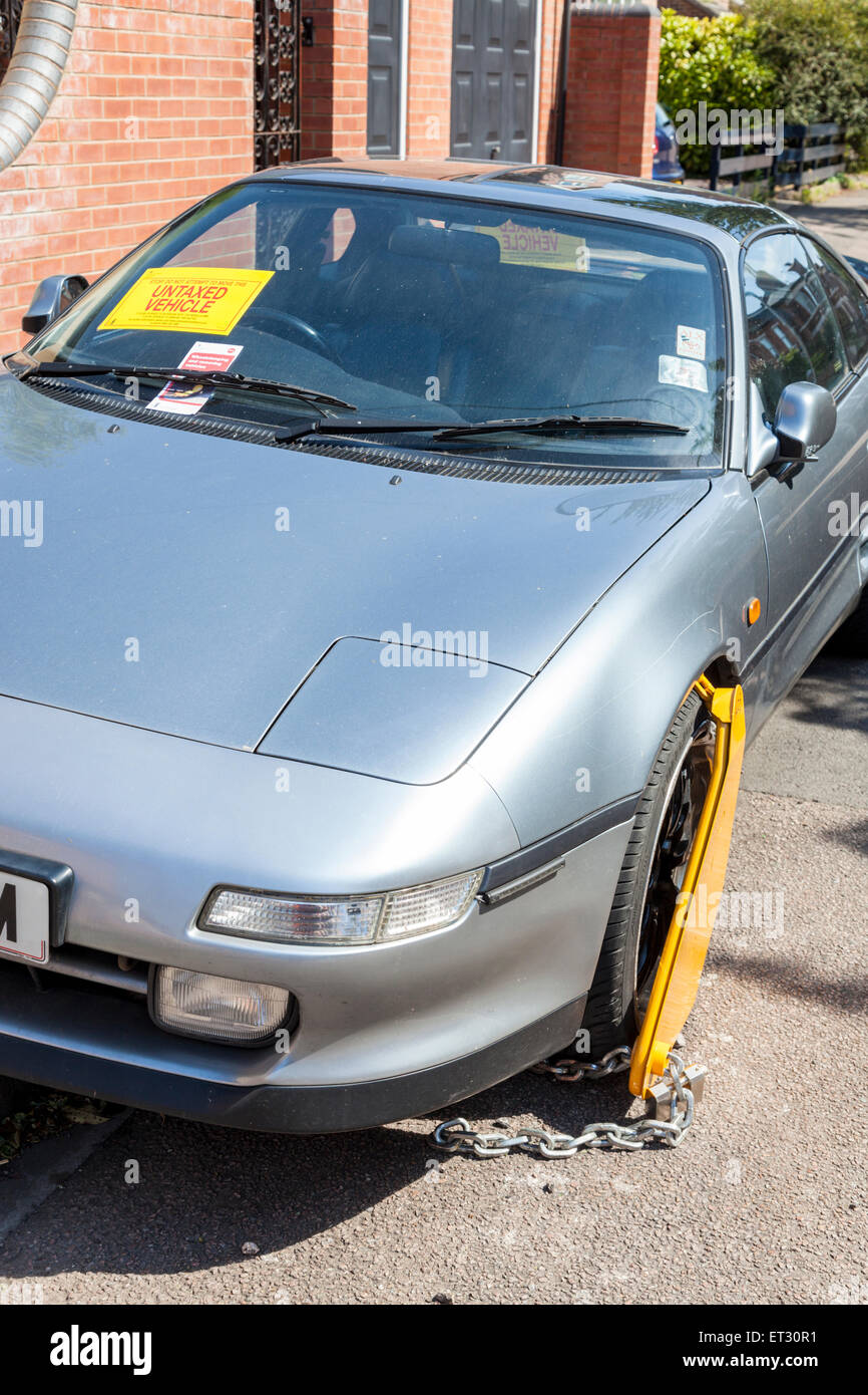 Permessi non tassati auto con ruota serrata e un avviso attaccato al parabrezza da DVLA, Nottinghamshire, England, Regno Unito Foto Stock