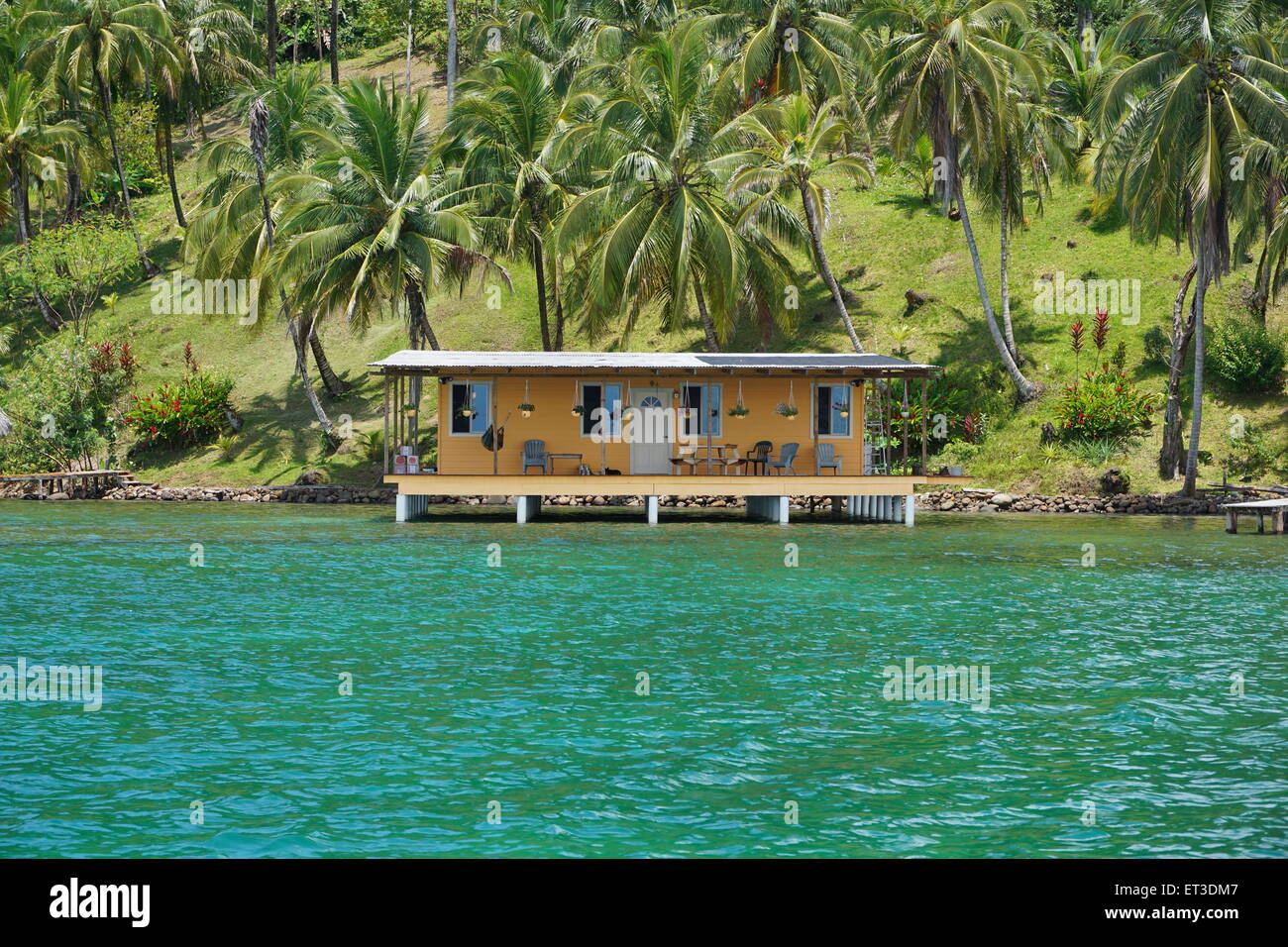 Proprietà costiere con palme da cocco e da una casa tropicale sull'acqua, il mare dei Caraibi, Panama America Centrale Foto Stock