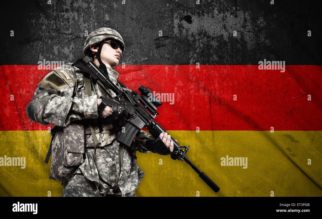 Soldato fucile a tenuta su una bandiera della Germania sullo sfondo Foto Stock