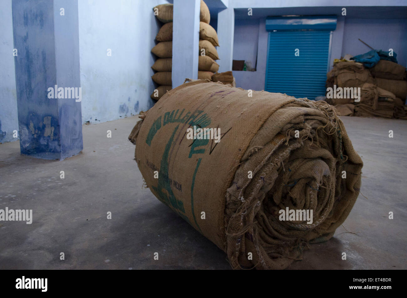 Un rotolo di sacchi giace inutilizzata in una distribuzione di zenzero warehouse in Fort Cochin, Kerala, India del sud Foto Stock