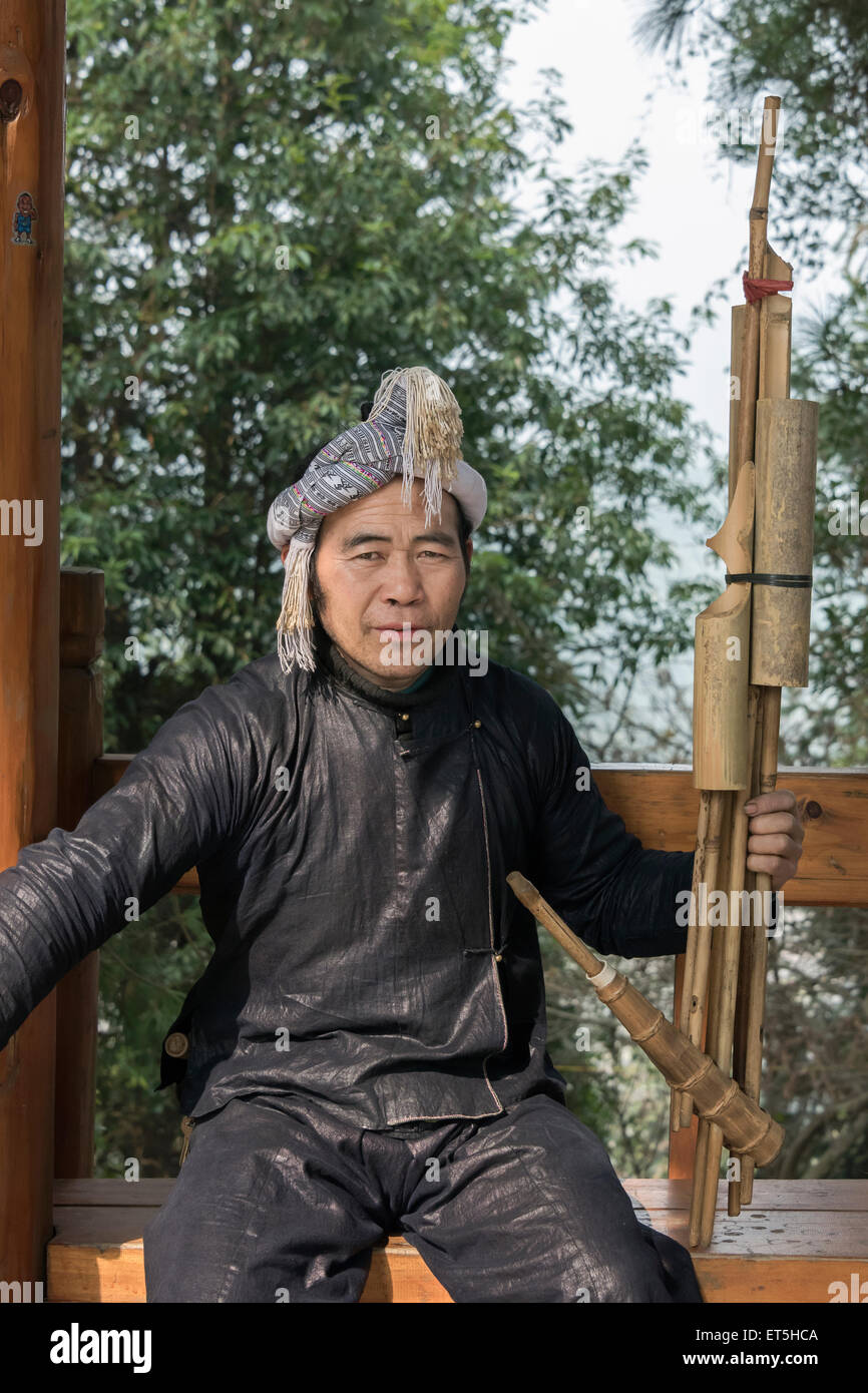 Basha Miao uomo con un lusheng strumento musicale realizzato da tubi di bambù, Basha Gun Village, Guizhou, Cina Foto Stock Basha Miao uomo con un lusheng strumento musicale realizzato da tubi di bambù, Basha Gun Village, Guizhou, Cina Foto Stock