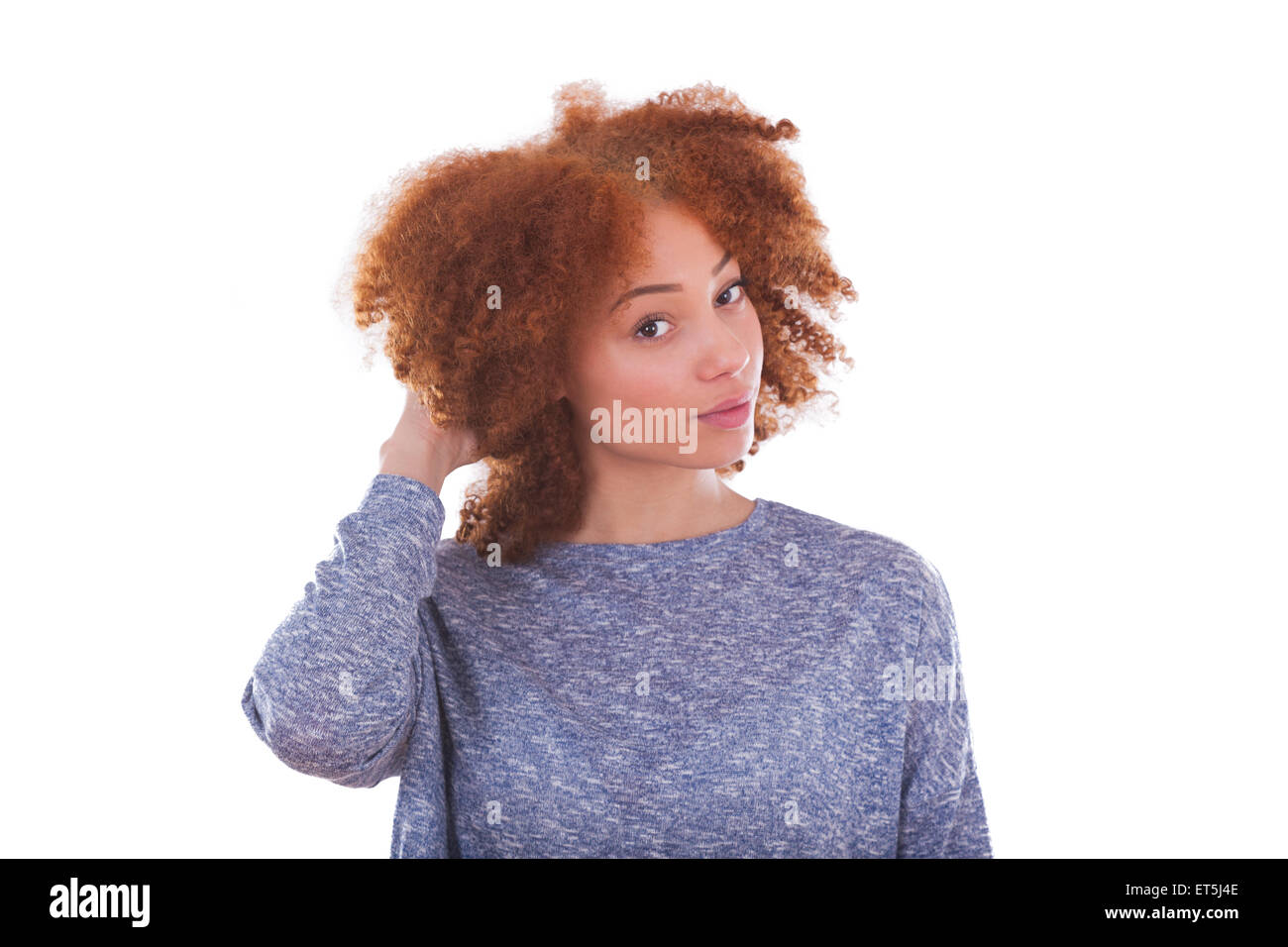 Giovane americano africano ragazza adolescente tenendo i suoi capelli ricci isolati su sfondo bianco Foto Stock