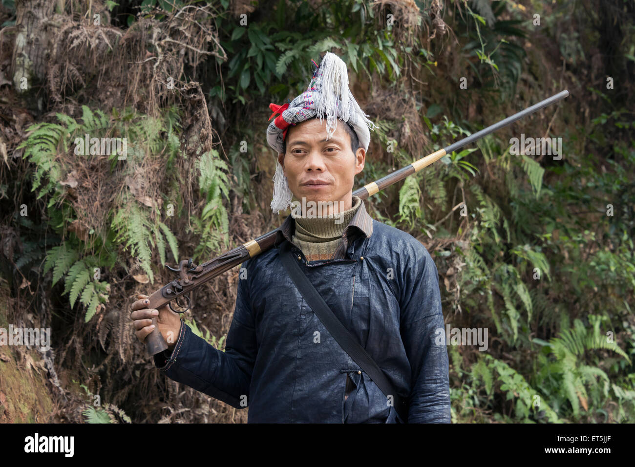 Di etnia Miao uomo con una lunga flintlock con impugnatura a pistola, fucile pistola Basha Village, Guizhou, Cina Foto Stock Di etnia Miao uomo con una lunga flintlock con impugnatura a pistola, fucile pistola Basha Village, Guizhou, Cina Foto Stock