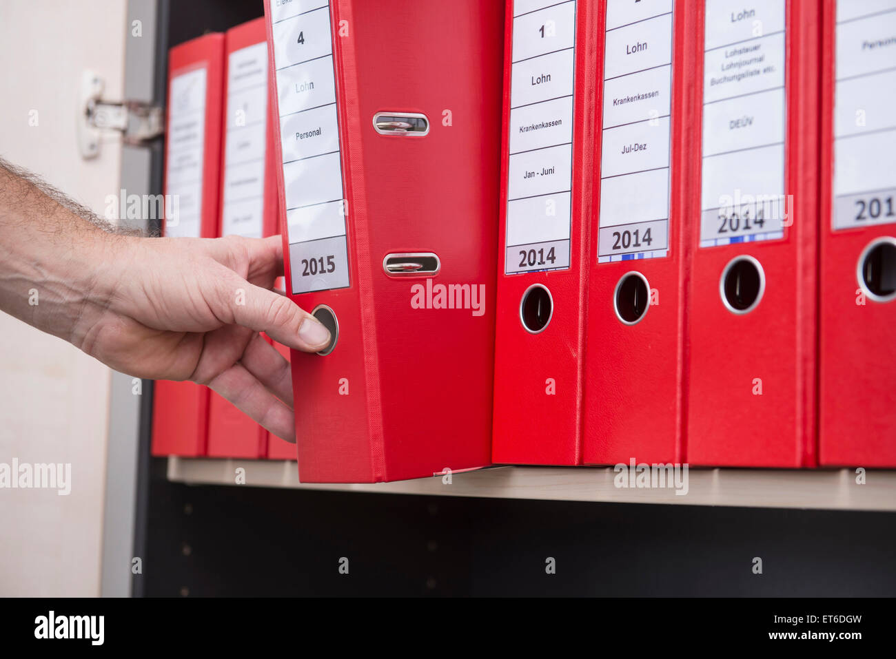 L'uomo prendendo file riservati da Filing cabinet, Monaco di Baviera, Germania Foto Stock