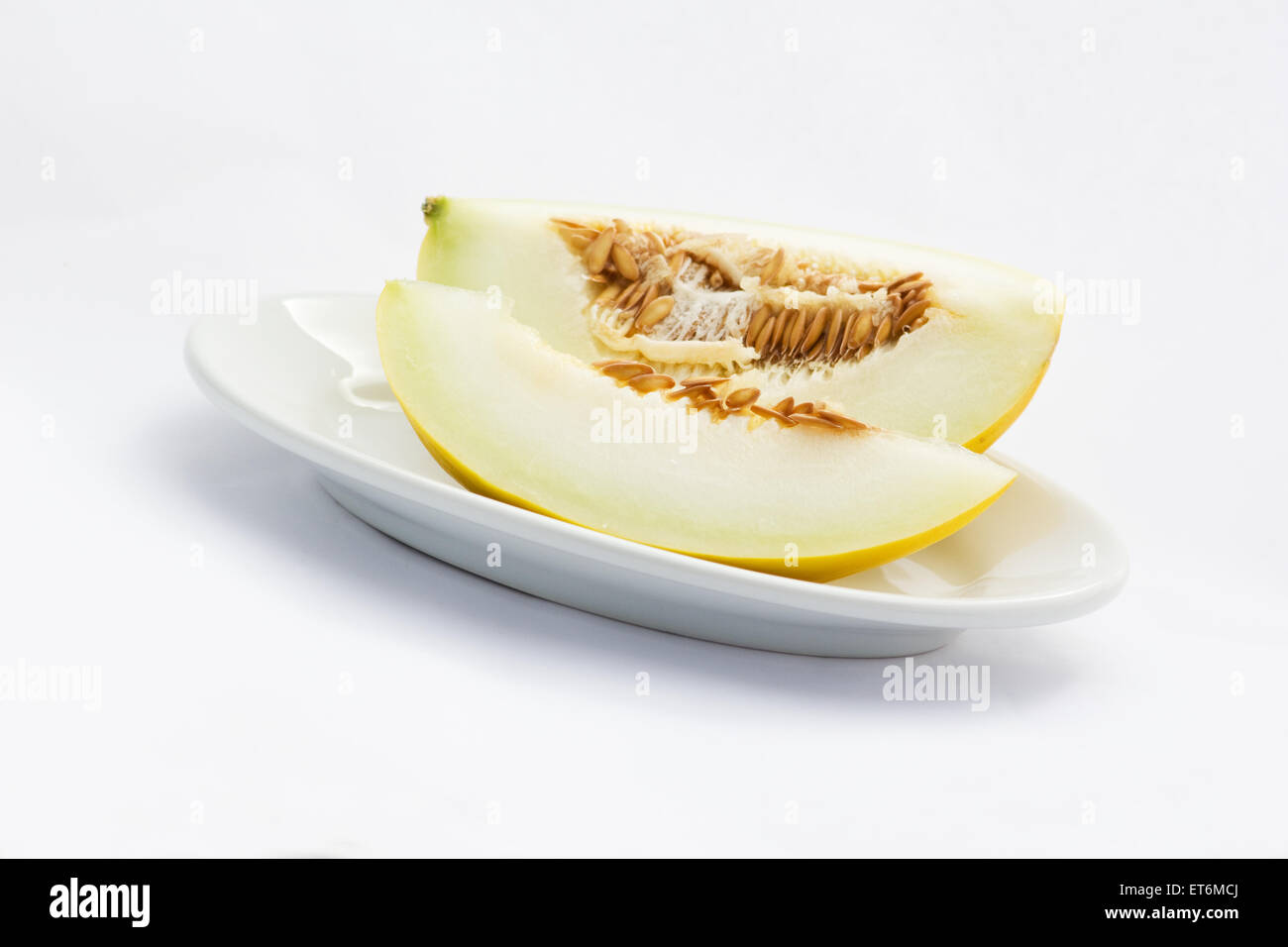 Canarie a fette di melone in una piastra su sfondo bianco Foto Stock