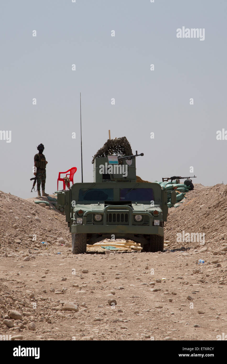 Peshmerga fighters pronti al Rash linea anteriore contro ISIS sulla periferia di Mosul. Il Peshmerga ha preso il controllo del vicino checkpoint dopo i militari iracheni fuggiti Mosul il 10 giugno. Questa unità è venuto sotto attacco razzo venerdì perdere uno e il ferimento di altre nove compagni soldati. Foto Stock