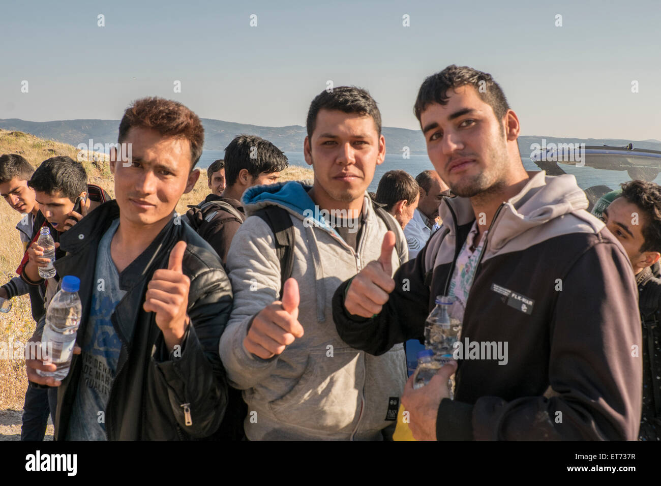 I rifugiati afgani dare pollice fino al loro arrivo sull'isola greca di Lesbo dopo aver attraversato dalla Turchia in un gommone Foto Stock