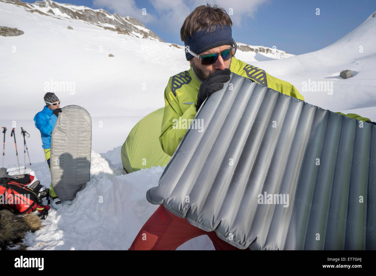 Due uomini per soffiatura in materassini per campeggio, Tirolo, Austria Foto Stock