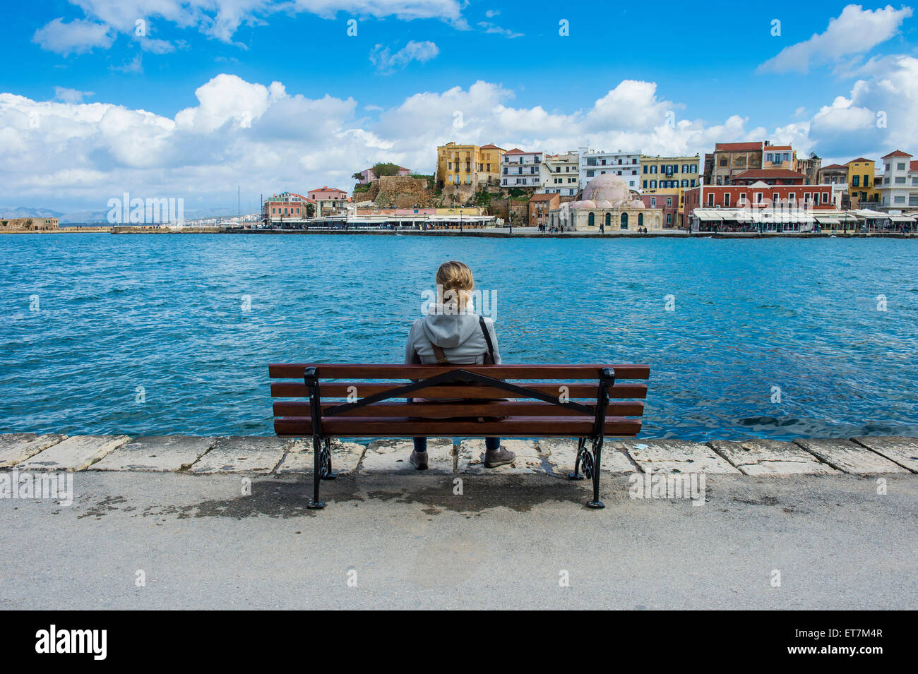 La Grecia, Creta, Chania, donna sul banco a porto veneziano Foto Stock