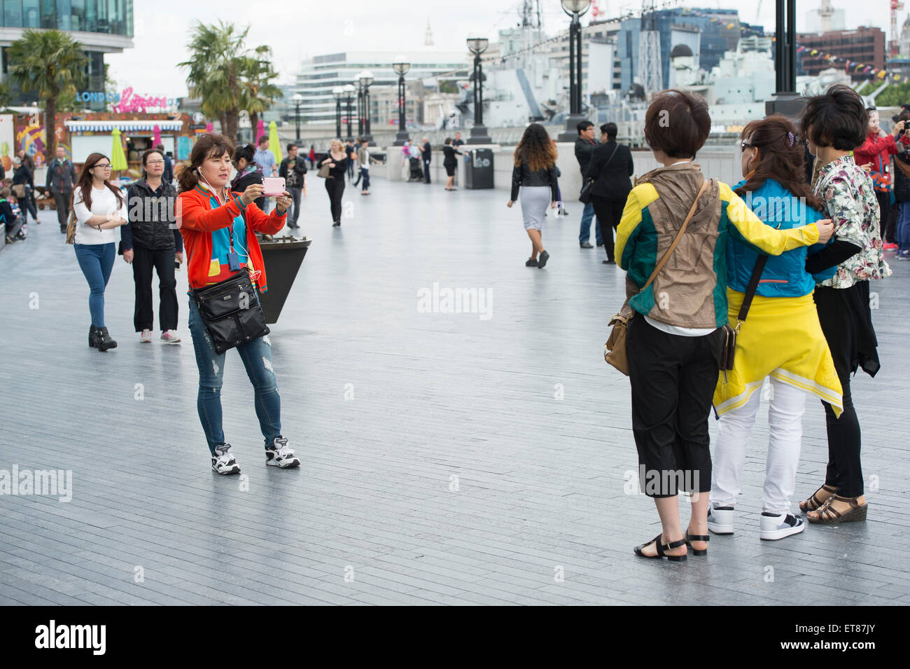 I turisti giapponesi a scattare foto in Londra con fotocamere, telefoni e bastoni selfie Foto Stock
