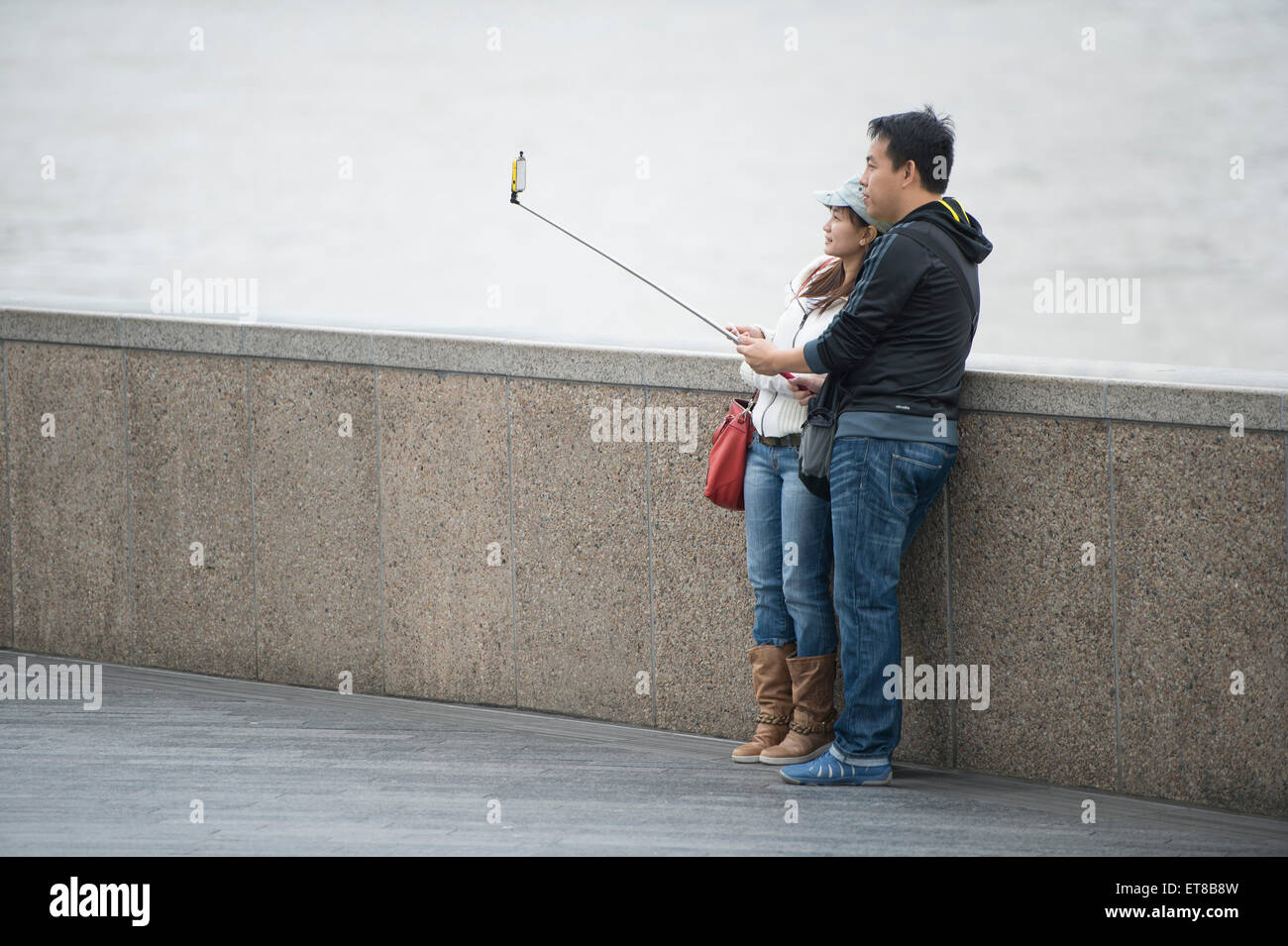 I turisti giapponesi a scattare foto in Londra con fotocamere, telefoni e bastoni selfie Foto Stock