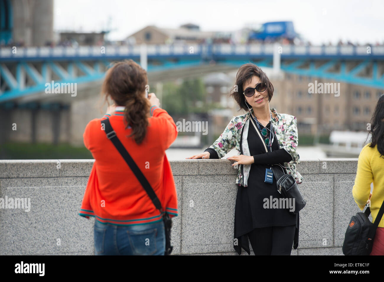 I turisti giapponesi a scattare foto in Londra con fotocamere, telefoni e bastoni selfie Foto Stock