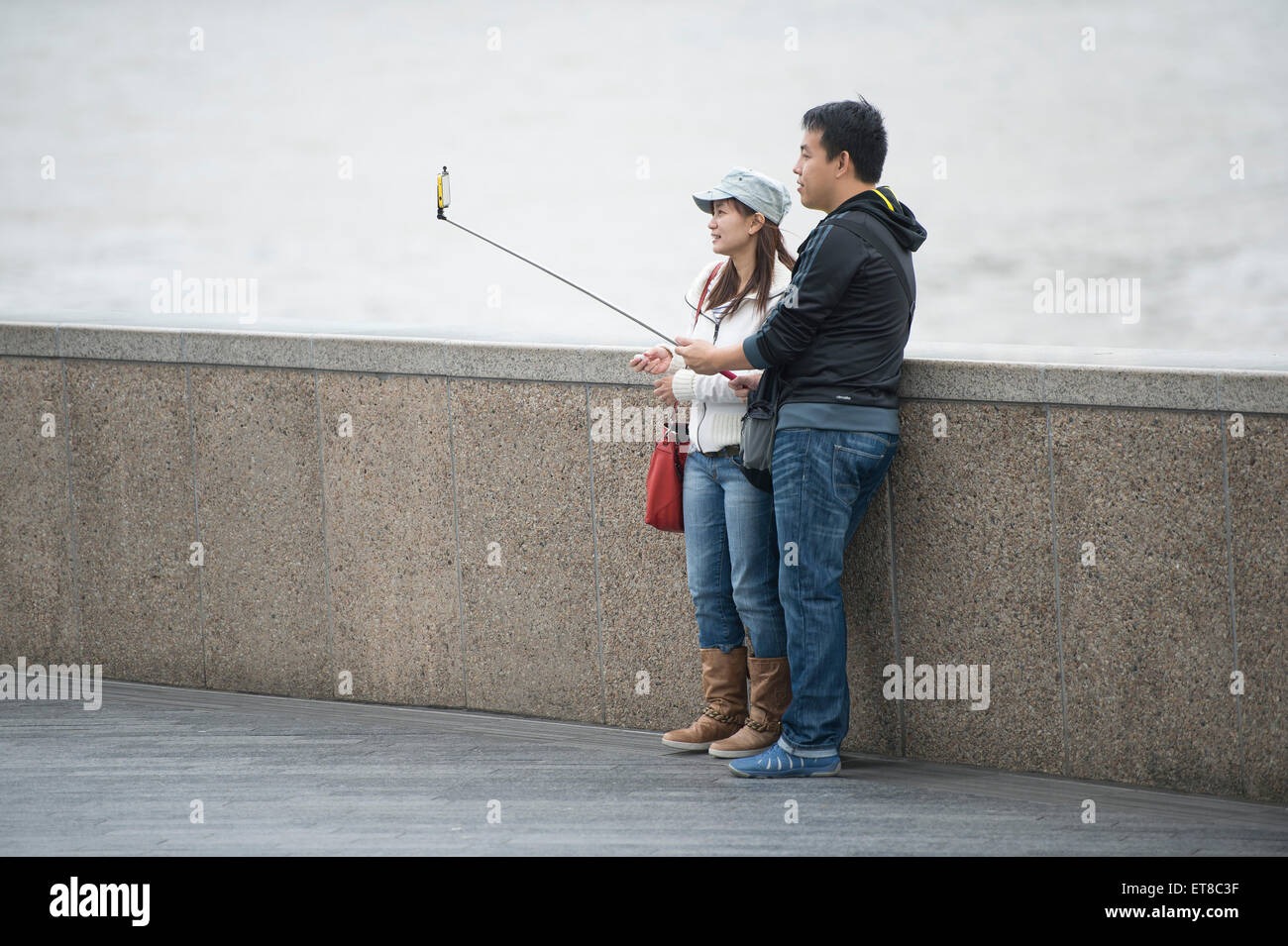 I turisti giapponesi a scattare foto in Londra con fotocamere, telefoni e bastoni selfie Foto Stock