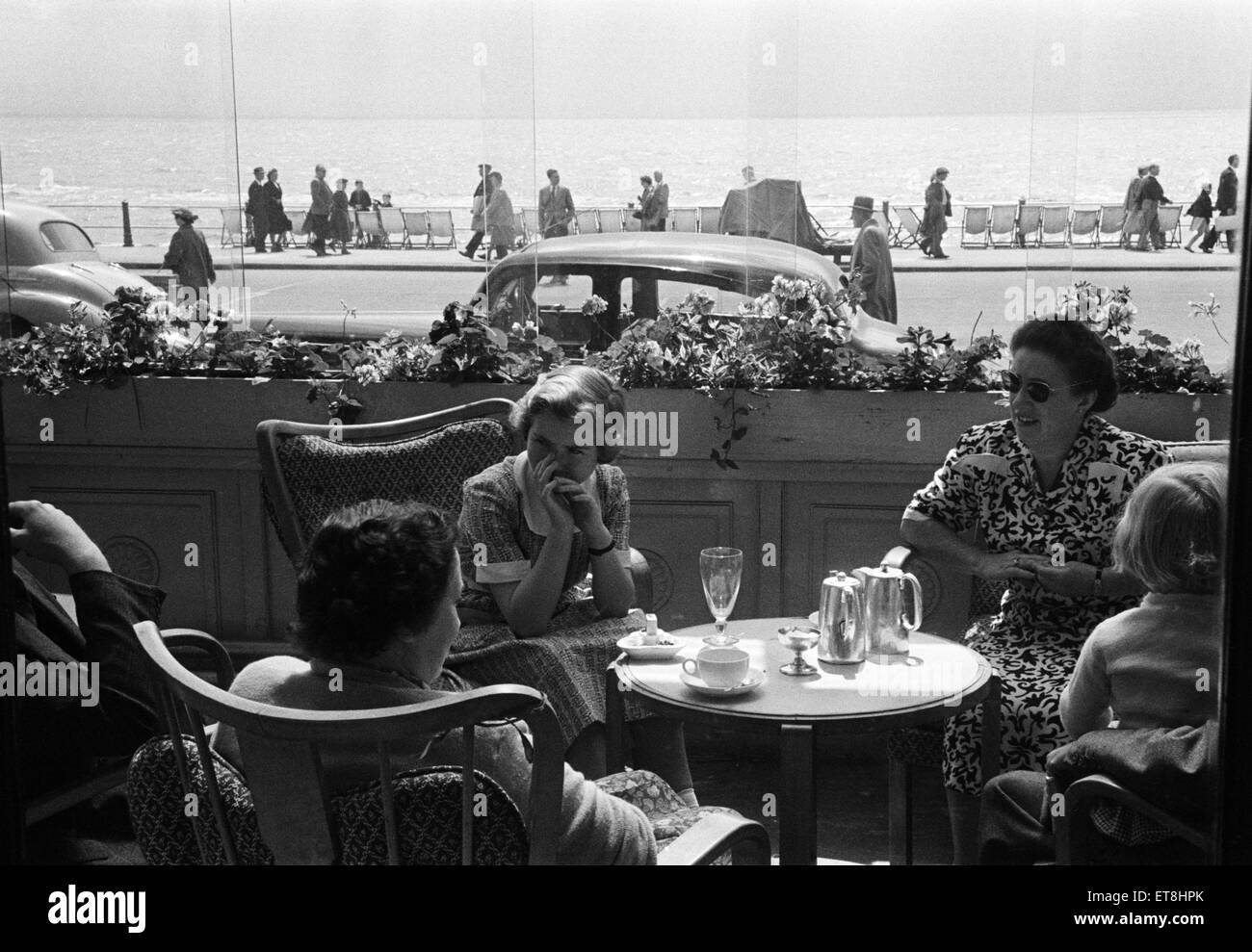 Holiday scene. in Hastings, East Sussex. I villeggianti gustando un tè pomeridiano in un caffè sul mare. Giugno 1952. Foto Stock