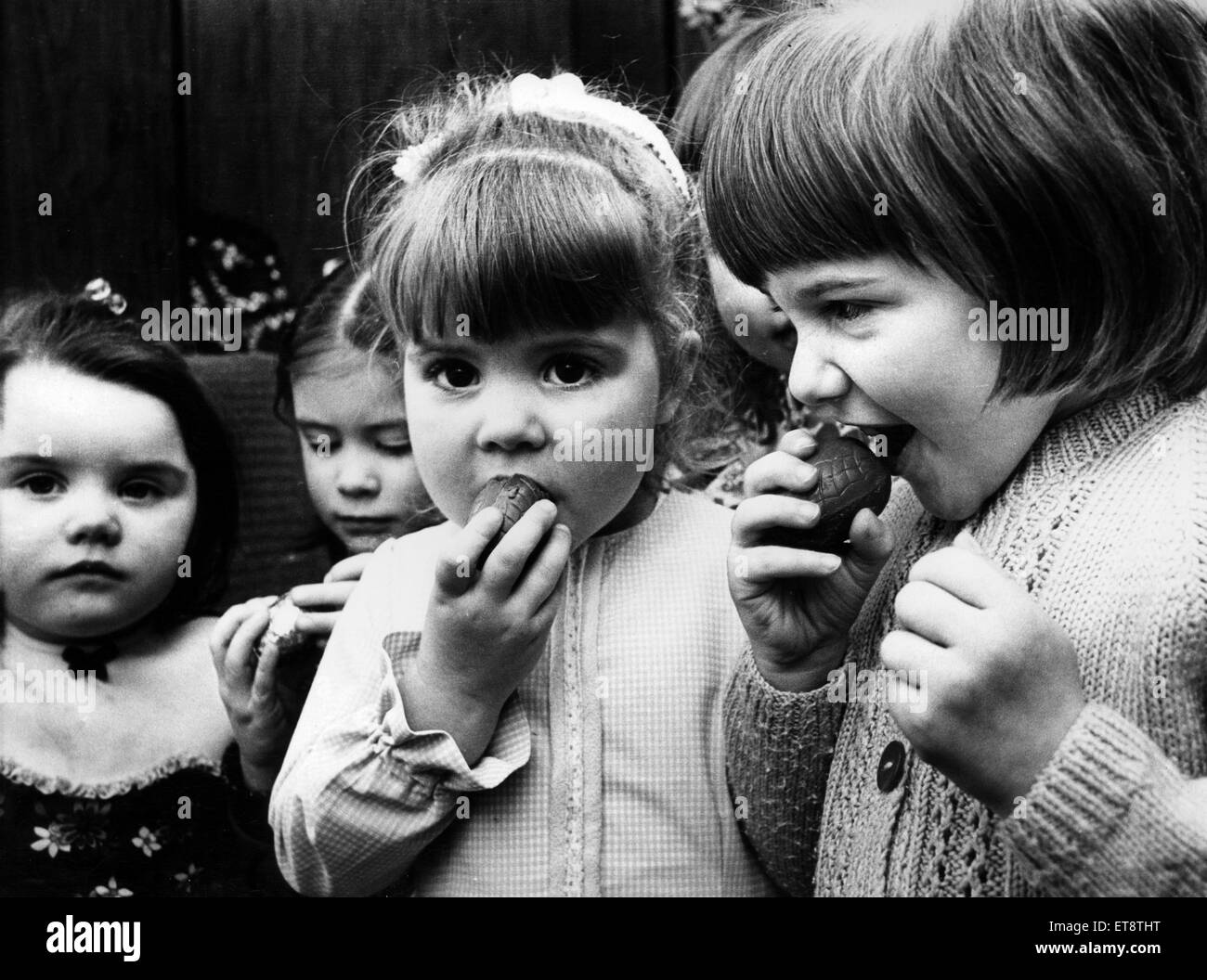 I bambini a mangiare il cioccolato uova di Pasqua, 27 marzo 1975. Foto Stock