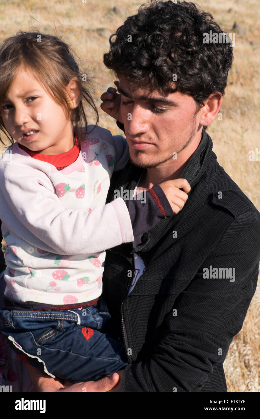 Afghane, padre e figlia rifugiati arrivano in Grecia dopo aver attraversato dalla Turchia in una zattera di gomma con altri rifugiati Foto Stock