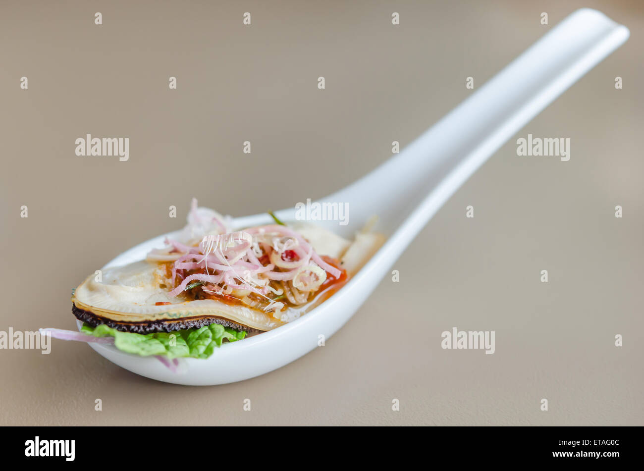 Cozza gigante con peperoncino piccante salsa a cucchiaio Foto Stock