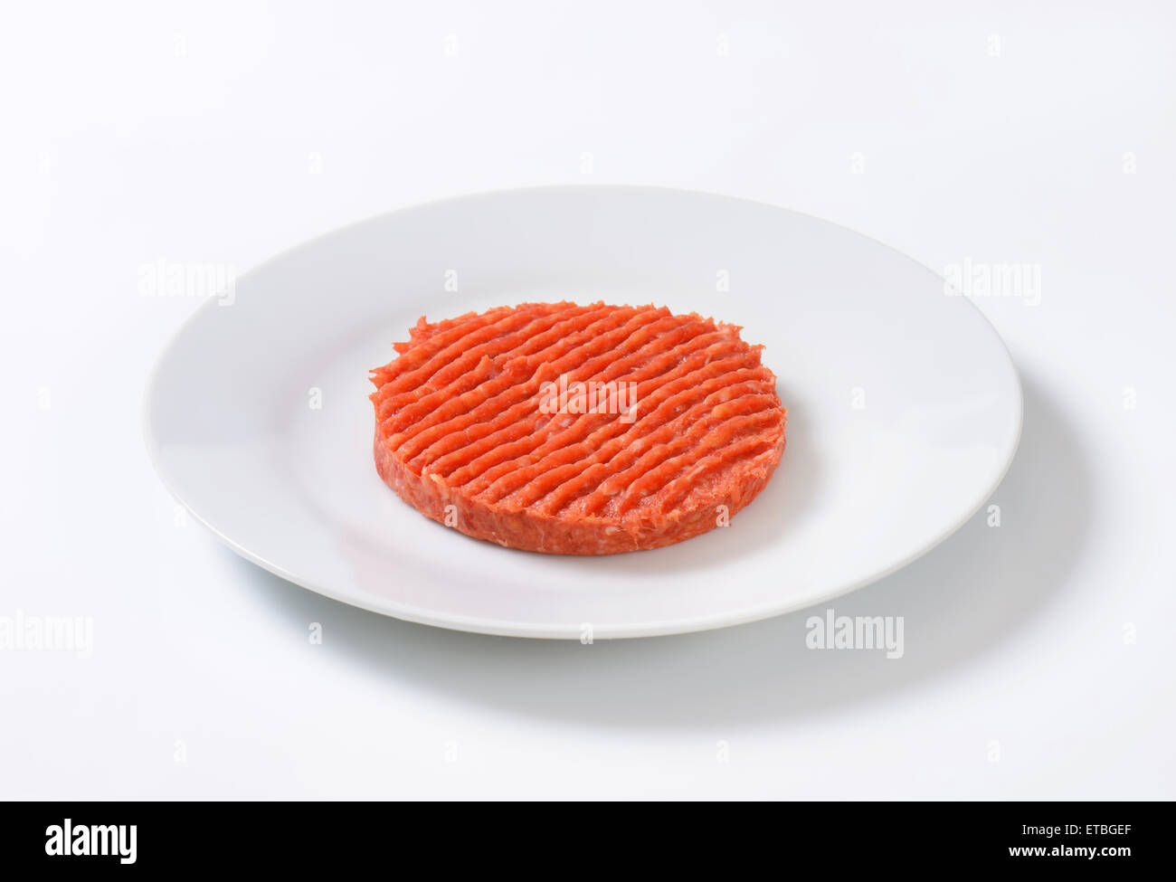 Materie hamburger patty sulla piastra bianca Foto Stock