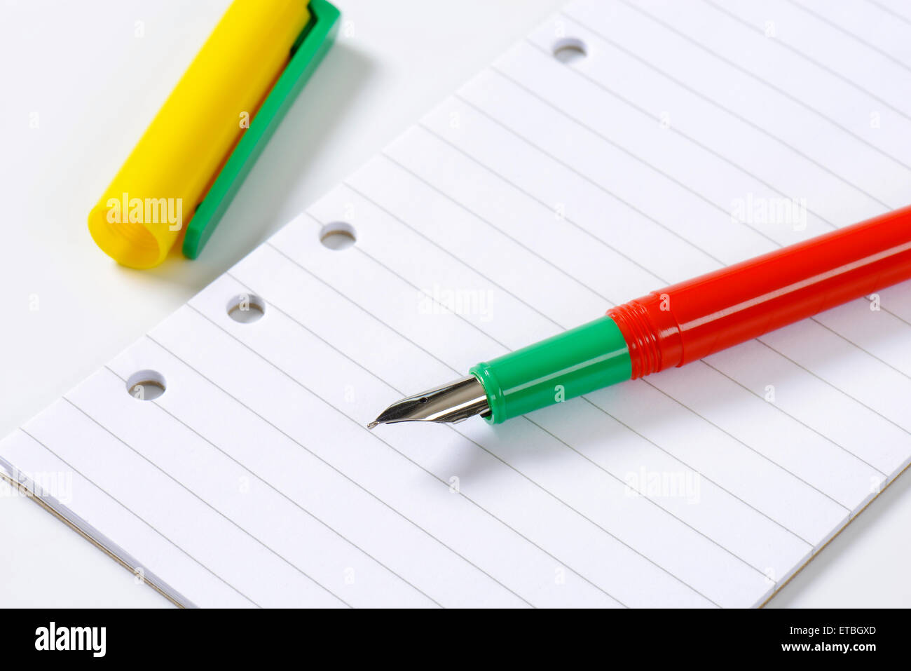 Penna stilografica senza cappuccio bianco su carta rigata Foto Stock