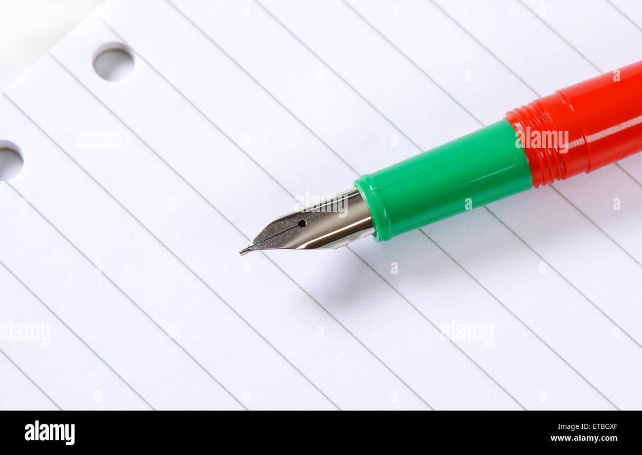 Penna stilografica senza cappuccio bianco su carta rigata Foto Stock