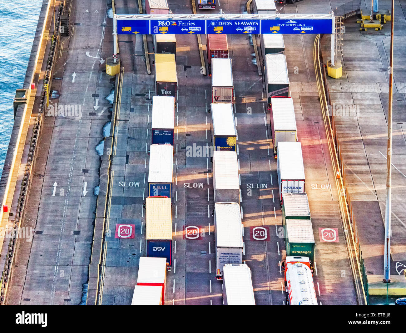 La linea di carrelli nel porto di mare con molti contenitori in attesa di essere spedito Foto Stock