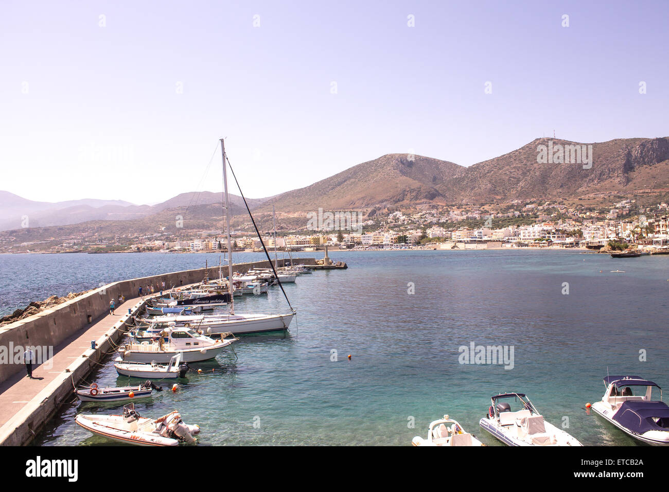 Barche schierate intorno al harbor in una popolare località turistica di Hersonissos Creta. Foto Stock
